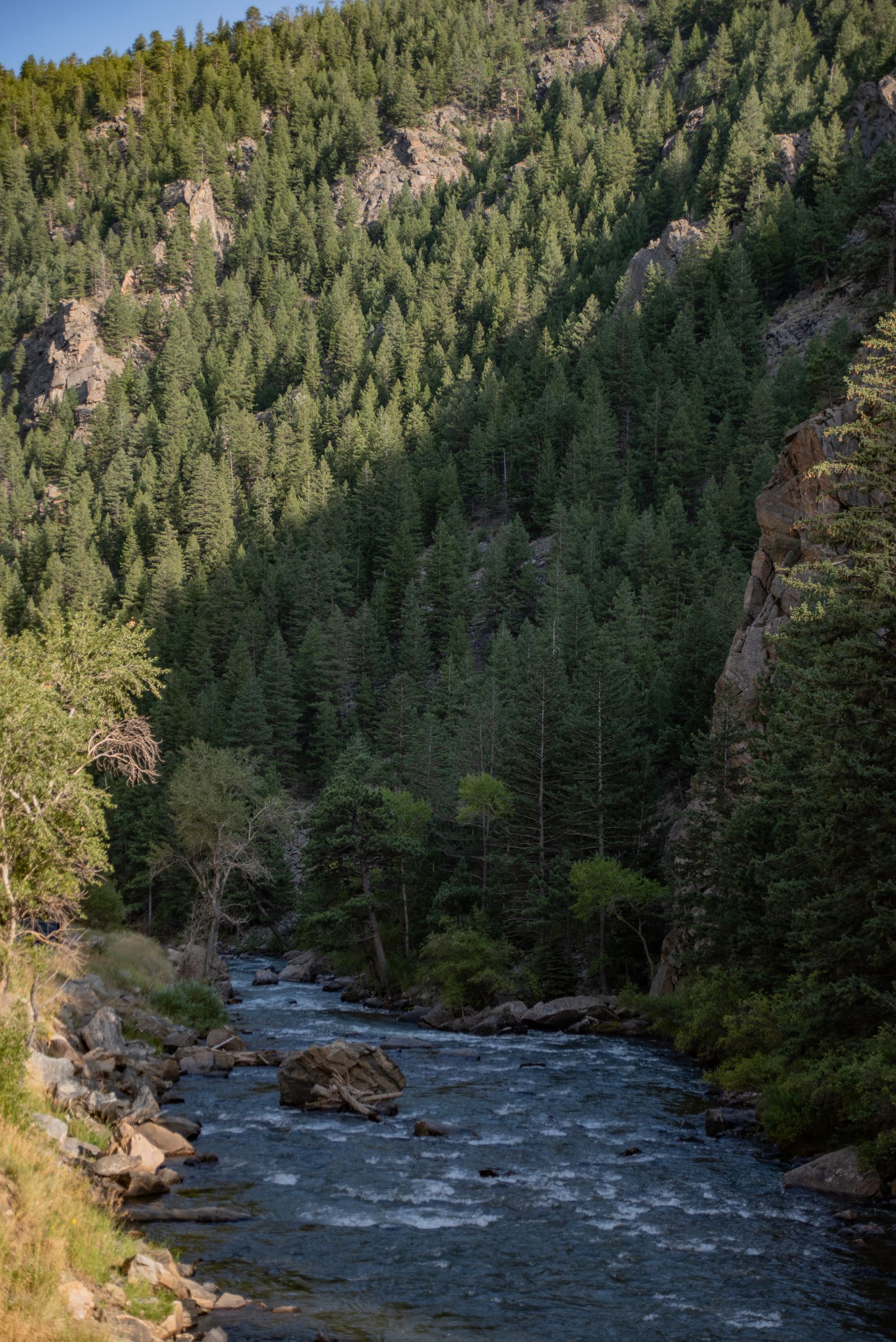 An alpine river and mountains glowing at golden hour